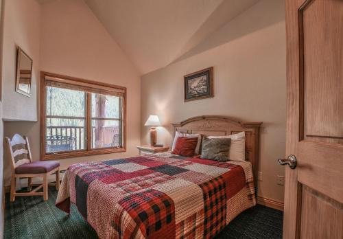 基斯通Hidden River Lodge 5995的一间卧室设有一张床和一个窗口