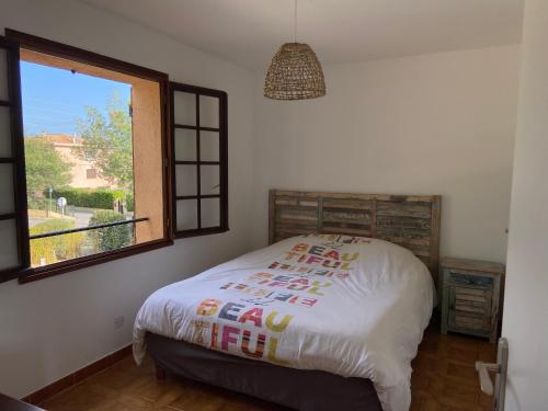 圣艾格夫Appartement de vacances au calme absolu, vue mer.的窗户和床罩的房间里一张床位