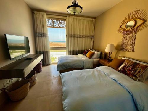 赫尔格达Mangroovy Seafront condo - Great Kite Surfing的酒店客房设有两张床和窗户。
