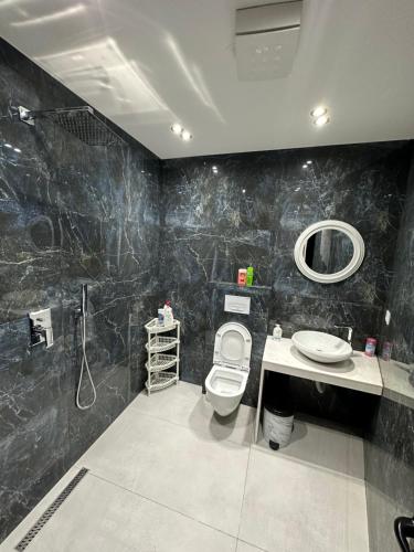 地拉那CozyStayApartments的一间带卫生间、水槽和镜子的浴室