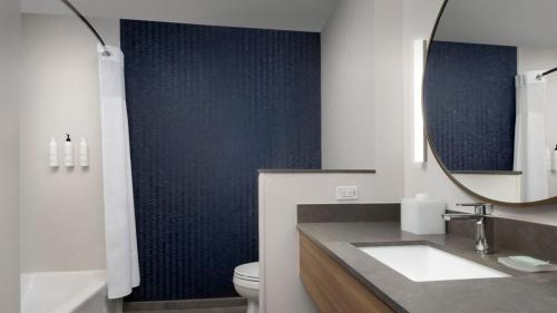 昆斯伯里Fairfield Inn & Suites by Marriott Queensbury Glens Falls/Lake George的一间带水槽、镜子和卫生间的浴室