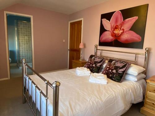 SeamerFryers Cottage, Seamer, 3 Bed cottage sleeps 5 people的卧室配有一张墙上大粉红色花的床。