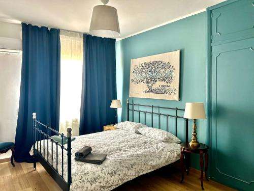 陶尔米纳Taormina Casa Sarina的一间拥有蓝色墙壁的卧室、一张床和窗户