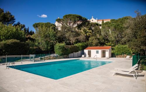 拉克鲁瓦瓦尔梅Suite Tropez, Résidence de prestige的一个带椅子和房子的游泳池