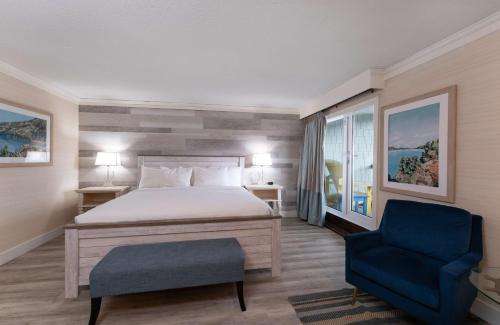 基洛纳Prestige Beach House, WorldHotels Crafted的一间卧室配有一张床和一张蓝色椅子