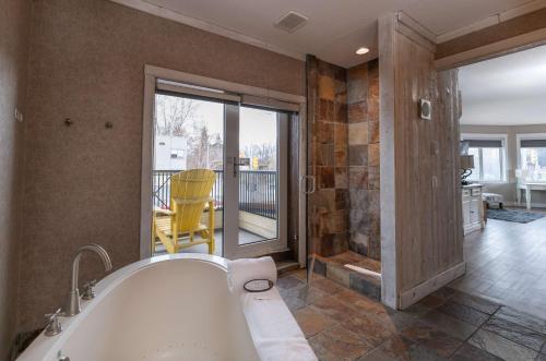 基洛纳Prestige Beach House, WorldHotels Crafted的带浴缸的大浴室和阳台