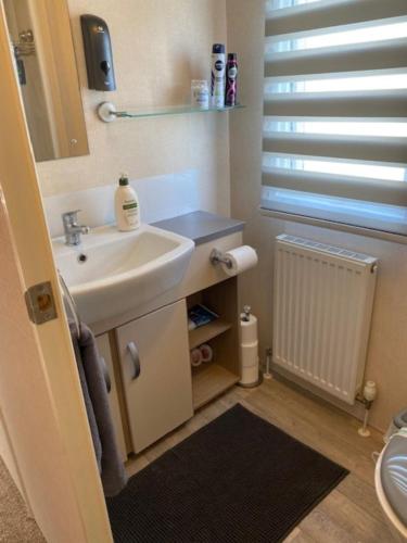 Littlestone-on-SeaSpacious Holiday Home - Romney Sands的一间带水槽和镜子的浴室以及窗户。