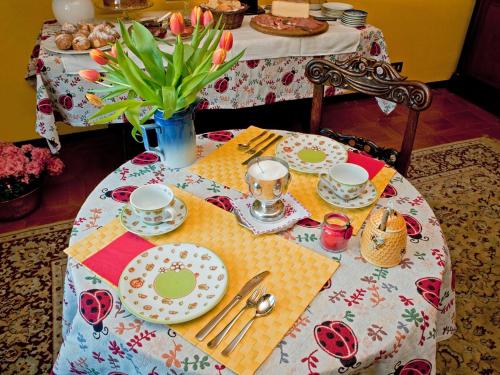 GrignascoLe Coccinelle B&B的桌子上摆着盘子和餐具