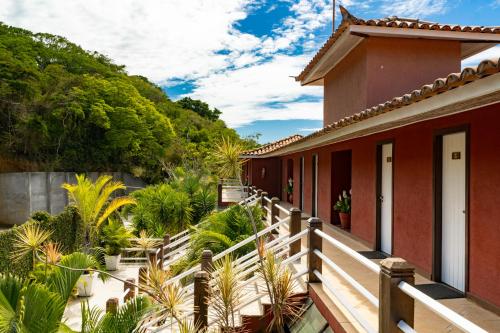 布希奥斯Riviera Búzios Hotel的一座带木阳台的别墅,种植了植物和树木
