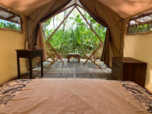 TandulujanggaCamp Tarimbang的帐篷内的卧室,配有一张床和一张书桌