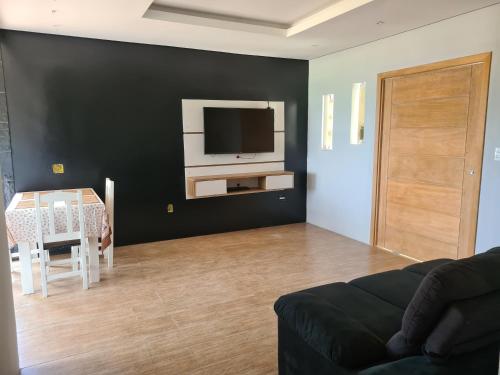 安格拉杜斯雷斯Casa Angra vista pro mar的客厅配有沙发和墙上的电视