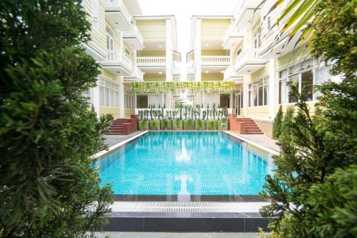 会安Hawal Boutique Villa Hoi An的一座树木繁茂的建筑中间的游泳池