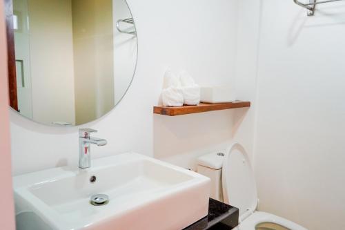 卢纳将军城Woody's Place Siargao的一间带水槽、镜子和卫生间的浴室