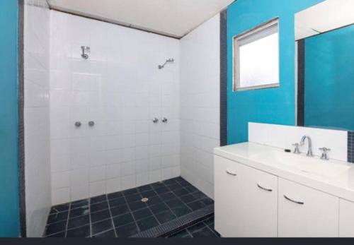 塞万提斯Cervantes Beach Shack的浴室配有白色水槽和淋浴。