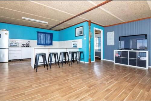 塞万提斯Cervantes Beach Shack的厨房拥有蓝色的墙壁,配有桌椅