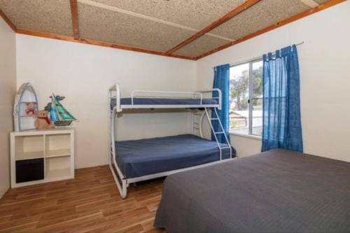塞万提斯Cervantes Beach Shack的一间卧室配有双层床和窗户。