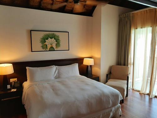 Sungai PelikSepang Golden PalmTree Family Villa 2 Bedroom的酒店客房带一张大床和一把椅子
