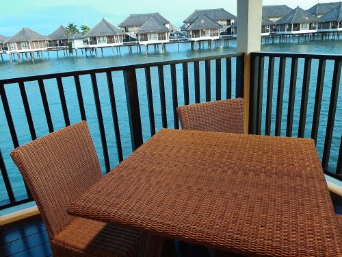 Sungai PelikSepang Golden PalmTree Family Villa 2 Bedroom的俯瞰水面的阳台配有桌椅