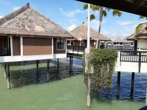 Sungai PelikSepang Golden PalmTree Family Villa 2 Bedroom的度假村水面上的一排简易别墅