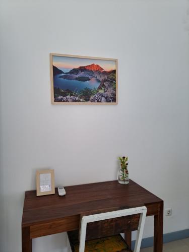 吉利特拉旺安Kubuwatu Boutique Accommodation的挂在木桌上方墙上的照片
