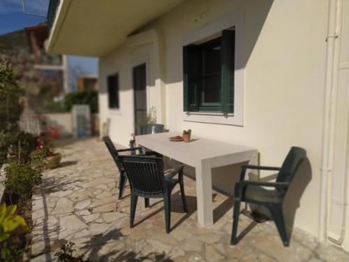 AnomeriáPerfetto Country House - Myrtos View的庭院里的白色桌椅