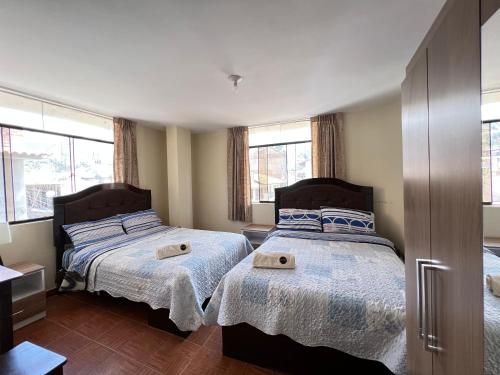 卡哈马卡Antara Hostal的卧室设有两张床,带两个窗户