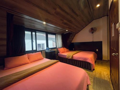 大叻Mina Thien Ha的一间卧室设有两张床和窗户。