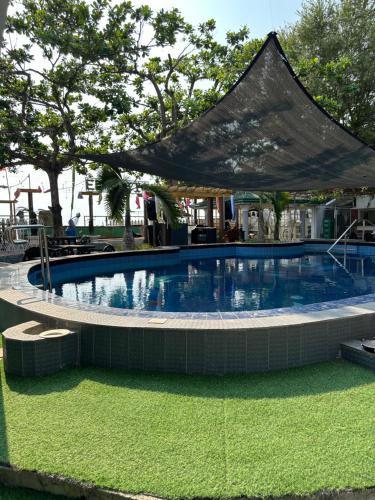巴旺Generosa Beach Club的一座大型游泳池,上面有帐篷
