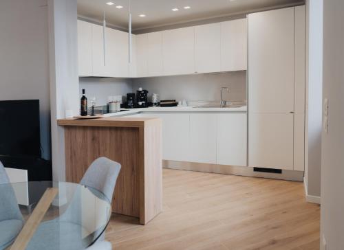 佩鲁贾Exclusive Apartment in Piazza Italia in Perugia的厨房配有白色橱柜和玻璃桌