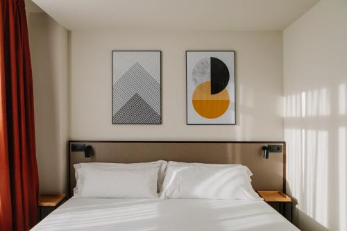 瓦伦西亚克莱默酒店的卧室配有一张墙上三幅照片的床