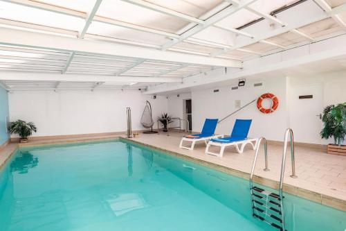 马赛马赛普拉多斐瑞尔公寓式酒店的一个带两把椅子的游泳池和一个游泳池