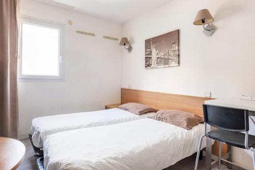 马赛马赛普拉多斐瑞尔公寓式酒店的一间卧室设有两张床、一张桌子和一个窗口。
