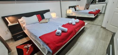 MeLux Airport House的一间大卧室,配有两张带红色毯子的床