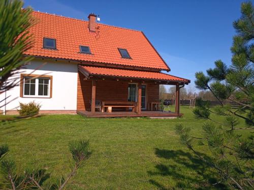 米科瓦伊基Stare Sady 25 EA的庭院上一座带橙色屋顶的房子