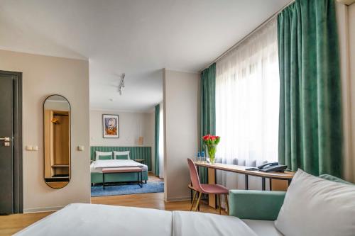 克拉科夫Hotel H12****的酒店客房,配有床和镜子