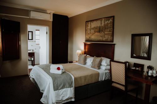 米德尔堡Alveston Manor Hotel的一间酒店客房,配有一张带毛巾的床