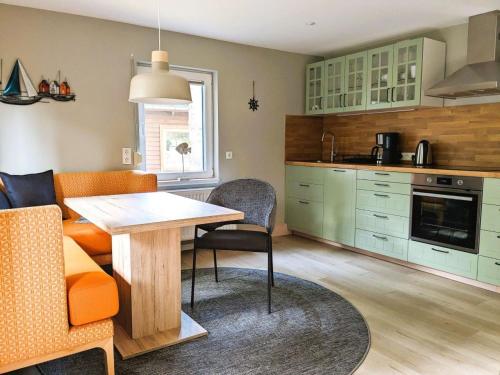 格洛韦Haus Lisa的厨房配有绿色橱柜和桌椅
