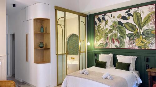 蒙彼利埃Home Chic Home - Les Suites de La Comédie的卧室配有一张床,墙上挂有绘画作品