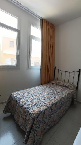 塔马达斯特布姆兰二号公寓的卧室内的一张床位,设有两个窗户