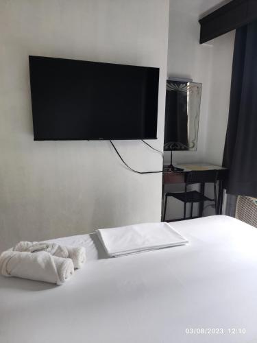 马尼拉Citadel Inn的卧室配有一张壁挂式平面电视的床。
