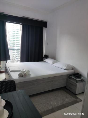 马尼拉Citadel Inn的一间卧室设有一张大床和窗户