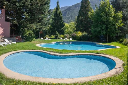 里贝拉德卡多斯嘉多斯酒店的一座位于庭院的游泳池,庭院里种有树木和山脉
