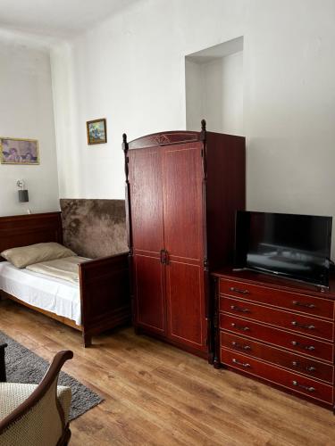 布达佩斯Kis Gellért Guesthouse的一间卧室配有一张床和一个带电视的梳妆台。