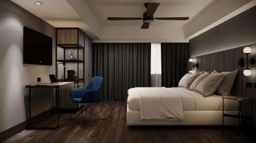 圣地亚哥-德尔埃斯特罗NH Santiago del Estero的卧室配有白色的床和蓝色椅子
