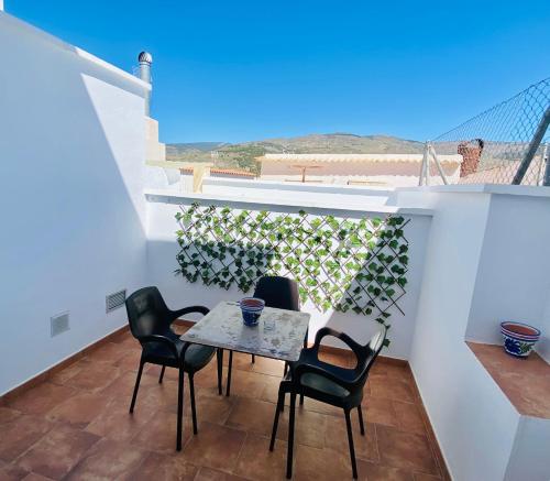丰东Apartamentos rurales, La Casa de Baltasar的阳台的天井配有桌椅