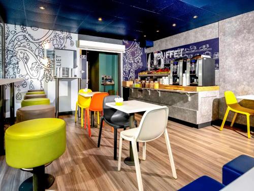 芒通芒通海岸宜必思快捷酒店的餐厅配有五颜六色的椅子、桌子和柜台