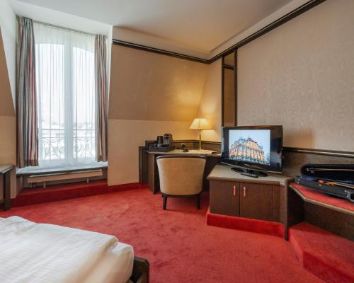 卢塞恩诺普尔卢塞恩酒店的酒店客房配有一张床和一张书桌及一台电视