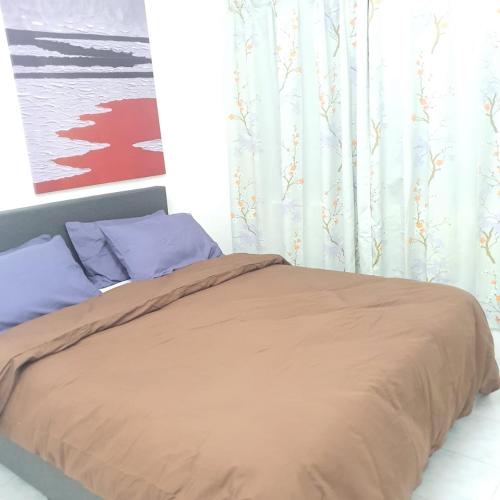 关丹KuantanBukitSetongkolArea3R2B.HTAA/TOWN-5min only的一张带棕色毯子和蓝色枕头的床