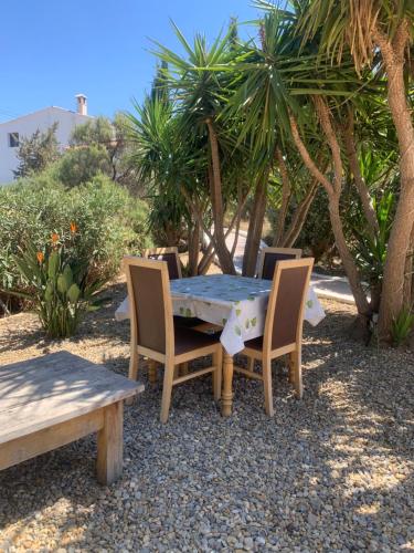 ArboleasLavender Lodge Almeria的棕榈树庭院里的桌椅