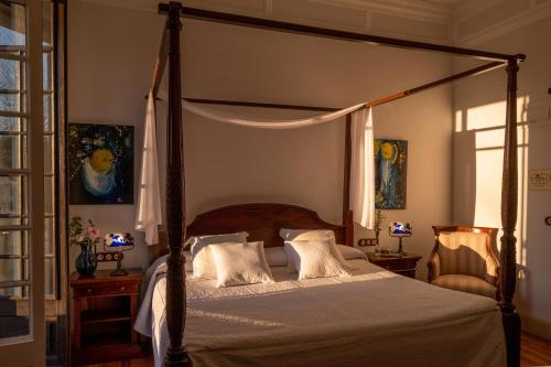 纳龙Hotel Pazo Libunca的一间卧室设有天蓬床和窗户。